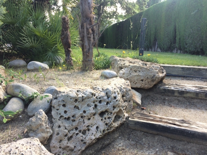 grandes rocallas decorativas en un jardín moderno con escaleras 