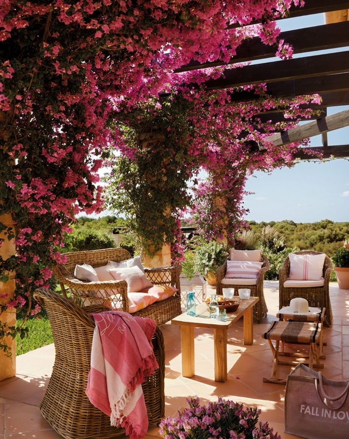 decoracion de jardines, sitio para pasar el rato con mubles de ratán decorado con flores colgantes en rosa
