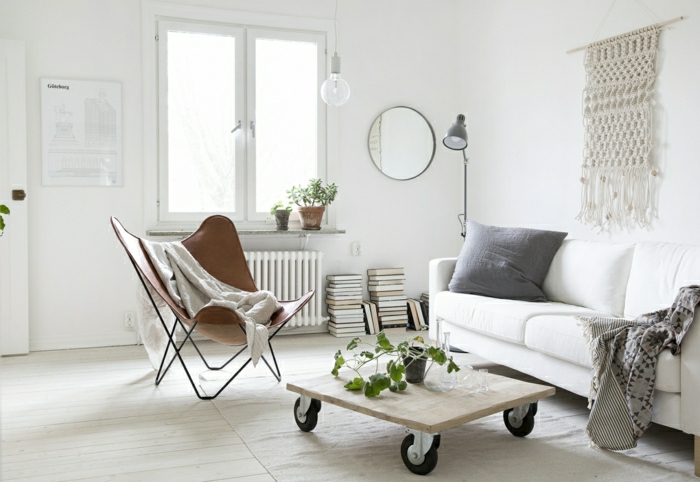 una idea simple de mesa de una parte del palet con ruedas grandes negras, sofa blanco con cojínes