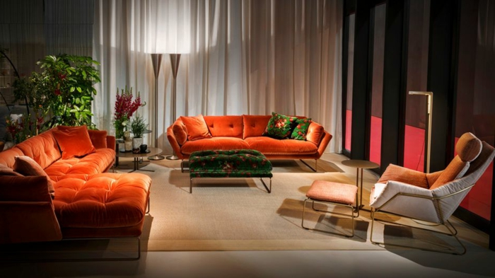 decoracion salon pequeño, con varios sofas de color coral de terciopelo con alfombra de marron clarito