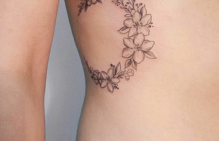 bonitos tatuajes para mujeres, corona de flores tatuada en las costillas, diseños de tatuajes pequeños y bonitos 