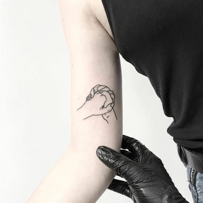 tatuajes simbólicos para hombres y mujeres, ideas de tatuajes para parejas, dos manos entrelazadas tatuadas en el brazo 