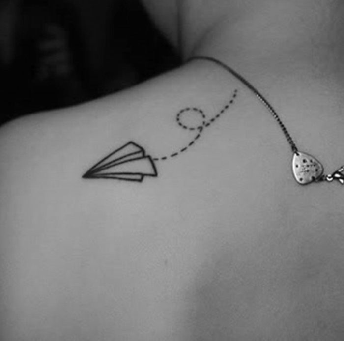 tatuajes discretos en la espalda con significado simbolico, avion de papel en vuelo tatuado en la espalda