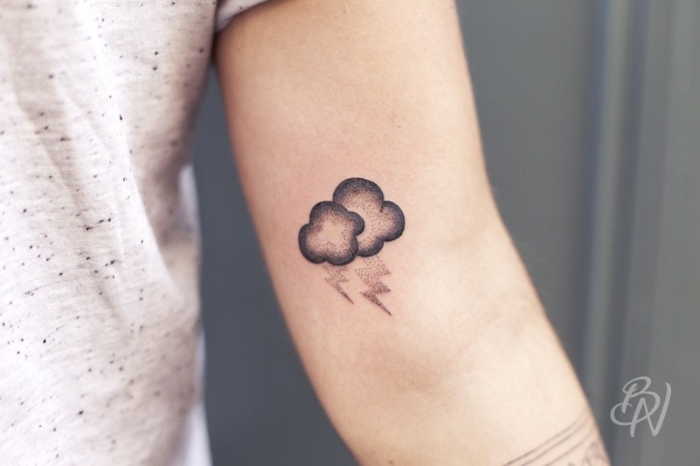 pequeño tatuaje en el brazo, simbolo de fuerza, dos nubes con truenos, tatuajes para mujeres 