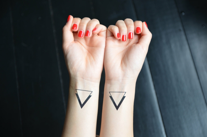tatoos pequeños en estilo minimaslita tatuados en las muñecas, tatuajes simbolicos con triangulo 