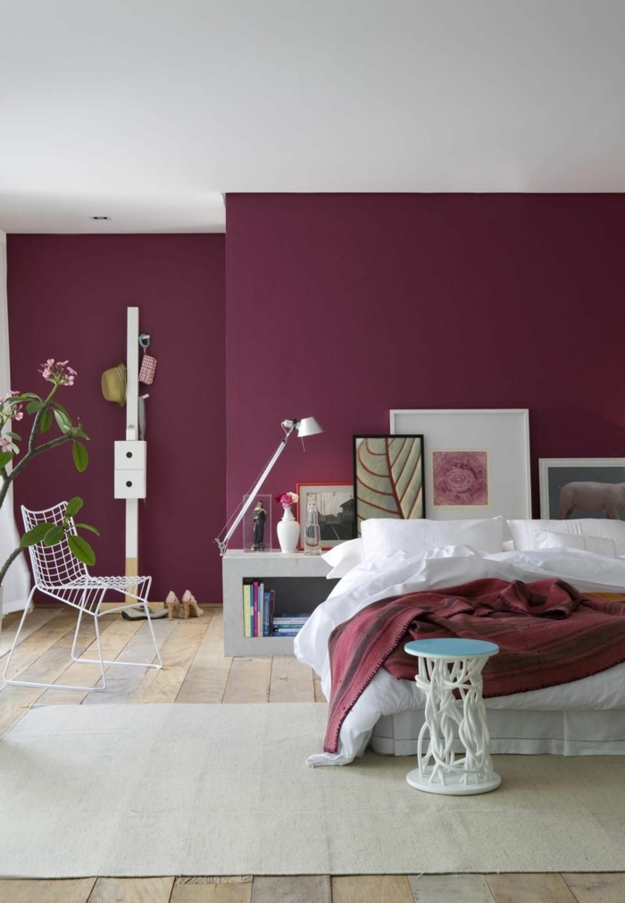 decoracion de dormitorios con paredes en color borgoña con alfombra en beige y suelo de parquet