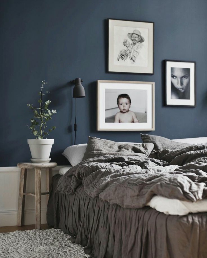 decoracion dormitorio matrimonio con paredes en azul pastel decorado con cuadros de personas y planta
