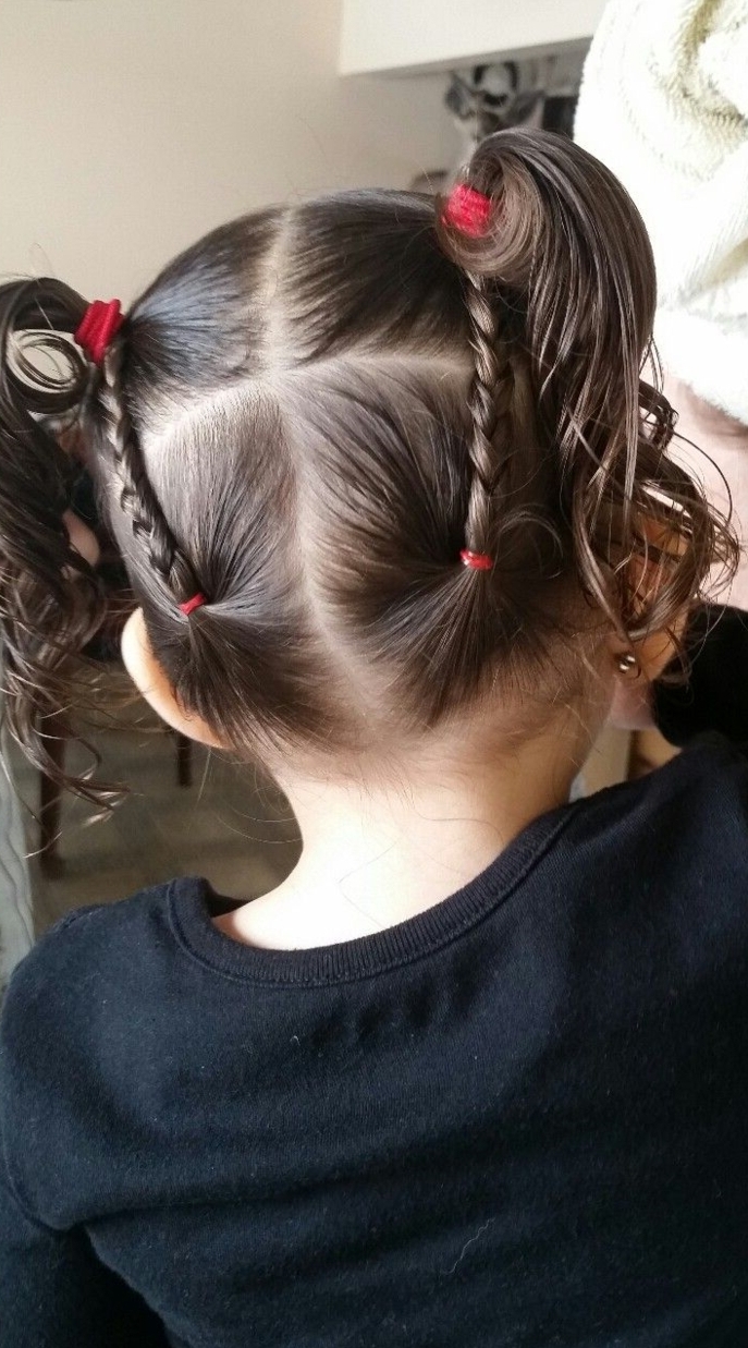 Peinados fáciles para niñas, niña vista por la parte de atrás con dos coletas con coleteros rojos y con trenzas en cada lado