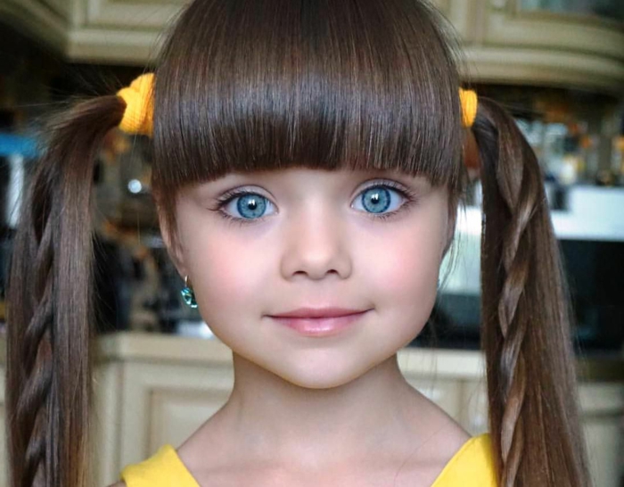 peinados de niñas faciles, niña modelo con gomas de pelo en color amarillo con coletas con trenzas