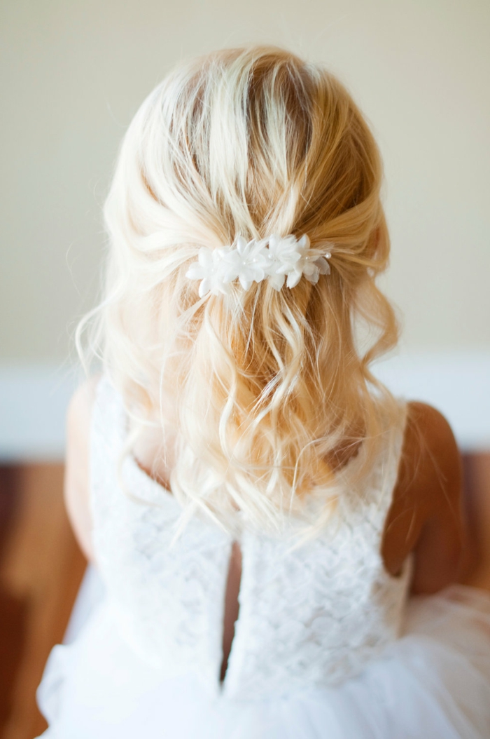 peinados faciles para niñas, rubia con el pelo suelto ondulado con horquilla largo con flores blancas y bolas
