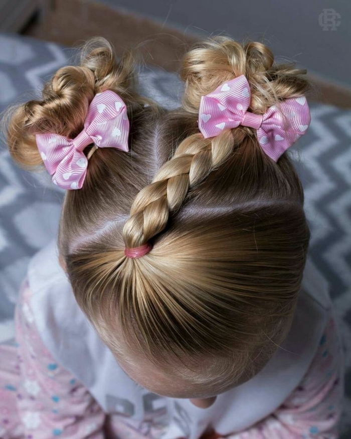 peinados para niñas de comunion, niña pequeña con dos moños en la cabeza con dos coleteros rosas