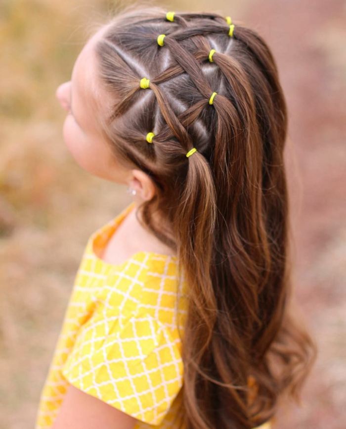 recogidos pelo largo, niña con gomas de pelo amarillas con el pelo con mechas entrelazadas formando figura