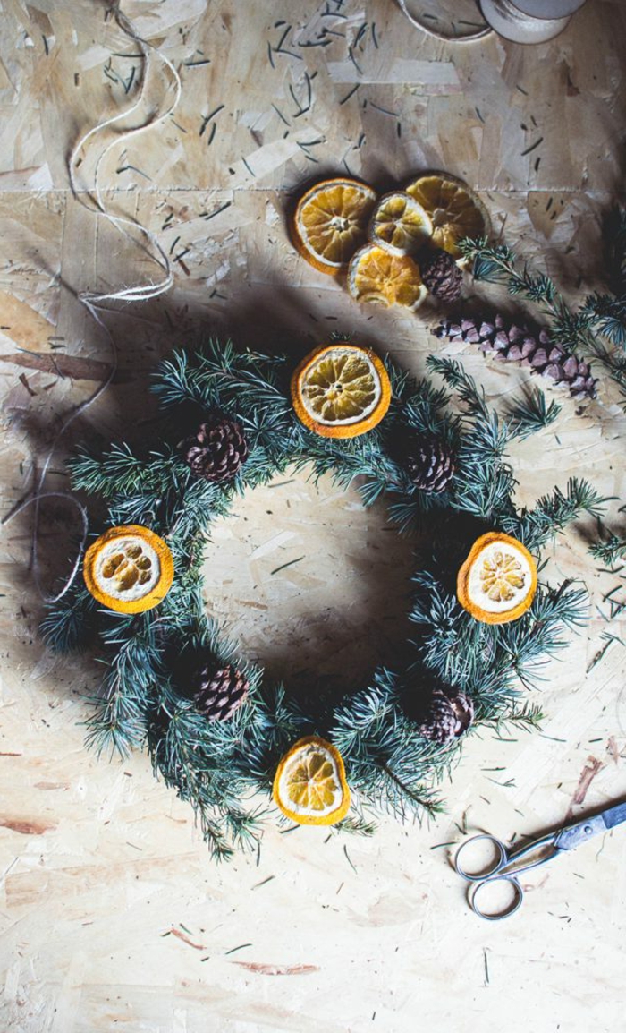 ideas de manualidades con piñas decoradas, guirnalda de navidad con frutas secas y piñas 