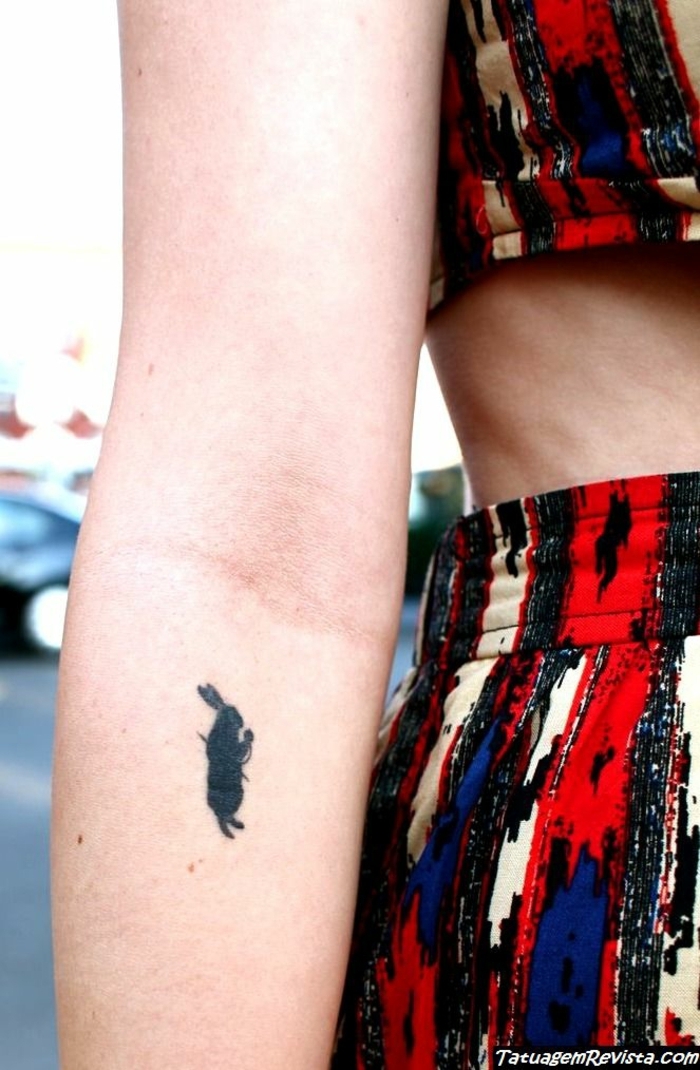 tatuaje original con gran significado, el conejo de alicia en el mundo de las maravillas tatuado en el brazo 