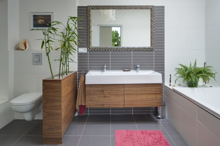 baño gris y blanco en estilo ecléctico, muebles modernos, espejo vintage y decoración de plantas verdes