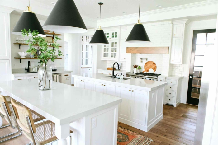 cocinas modernas blancas con islas, decoración moderna, dos islas multifuncionales en blanco, suelo de parquet y lámparas en negro 