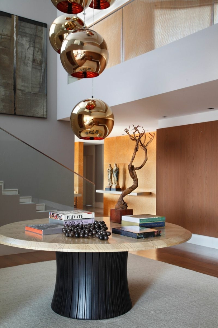 creativas ideas sobre decoración de recibidores pequeños, mesa baja redonda de madera, lámparas en dorado 