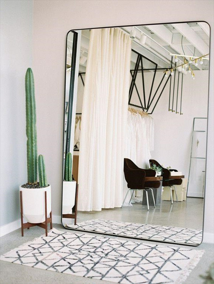 mueble recibidor modernos, grande espejo apoyado en la pared, alfombra pequeña ornamentada