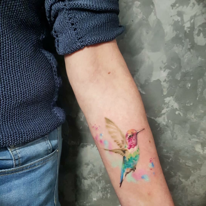 ave colibri tatuado con pinturas acuarela, ideas creativas de tatuajes en el antebrazo para hombres y mujeres 