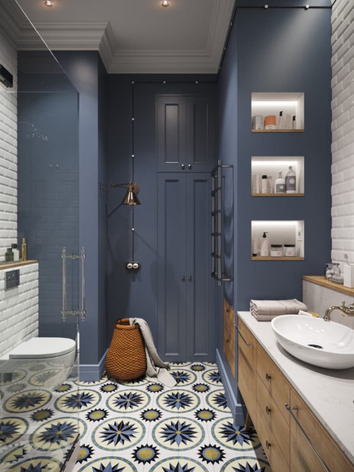 azuejos de baño suelo con baldosas con figuras geométricas, paredes en azul pastel, lavabo blanco