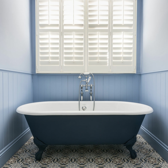 azulejos para baños, bañera de color negro, con suelo de baldosas de motivos étnicos, ventana grande