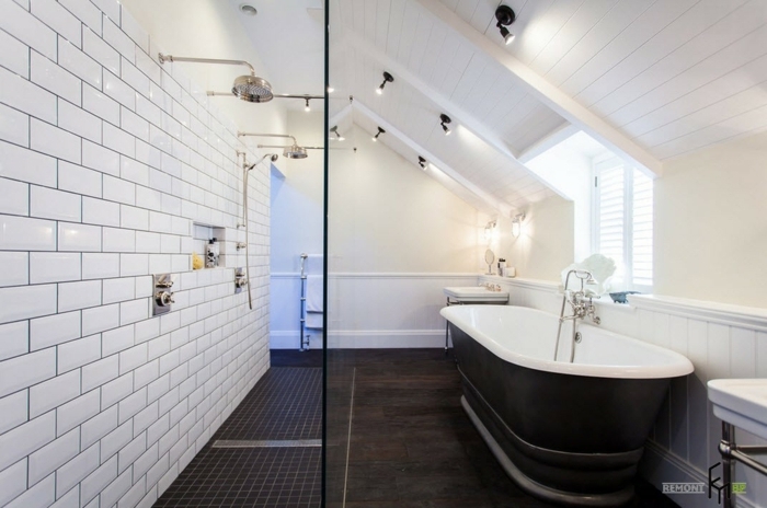 reforma baño pequeño abuhardillado, bañera en negro, paredes con azulejos en blanco 