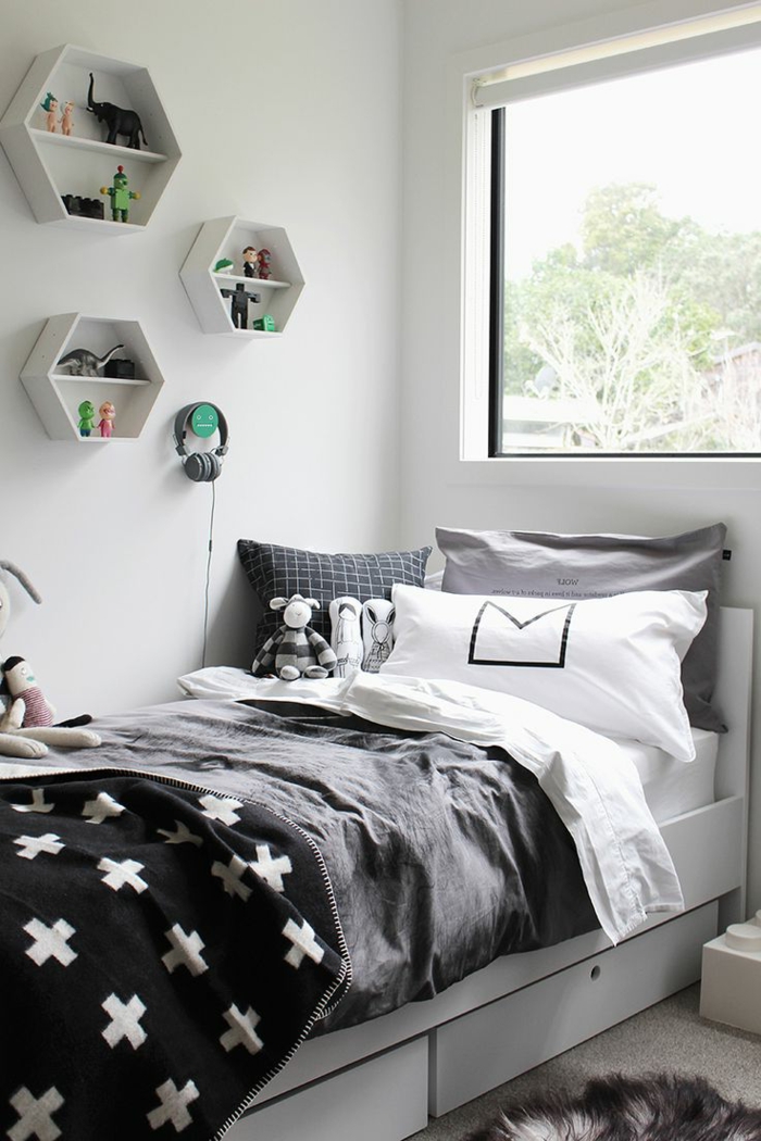 habitaciones juveniles niña, cama con sábanas en negro, blanco y gris con estanterías en la pared