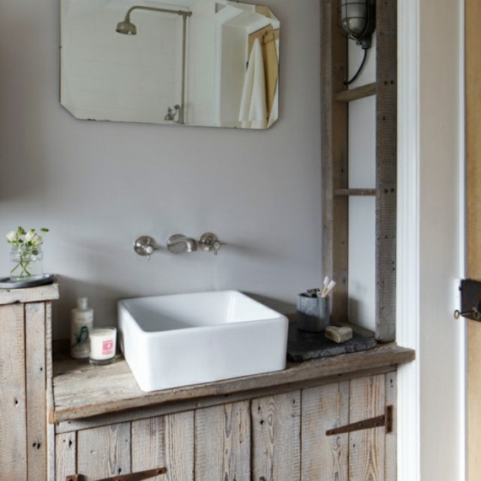 pequeño baño decorado en estilo rústico, armario de madera y espejo vintage, paredes en gris claro 