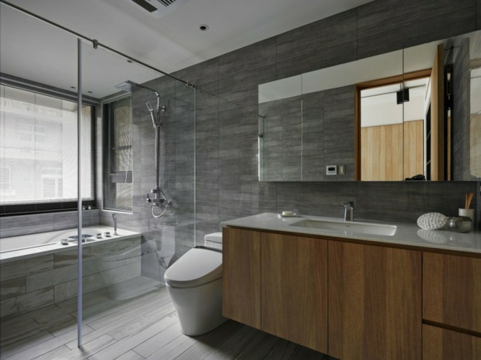 decoración de encanto baño grande, suelo de parquet, armario grande de madera y paredes con azulejos en gris 