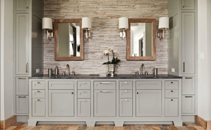 baño grande con suelo azulejos que imitan parquet, armarios en gris claro, dos espejos con marcos de madera 