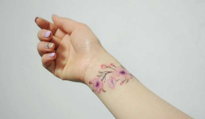 precioso tatuaje en la muñeca con flores, diseños elegantes y femeninos mujer, tatuajes en el antebrazo