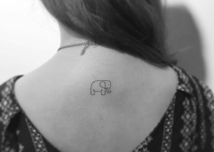 pequeño elefante tatuado en la espalda, ideas de tatuajes simbólicos con animales, tattoo con una sola línea contínua