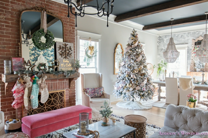 salon decorado con mucho encanto, pared de ladrillo, chimenea de leña, grande espejo vintage, árbol de navidad en colores pastel, arboles de navidad originales