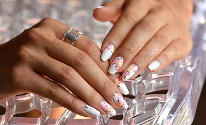 diseño de uñas acrilicas en colores pastel, fondo blanco y motivos florales en rosado, decoración uñas largas de forma ovalada 