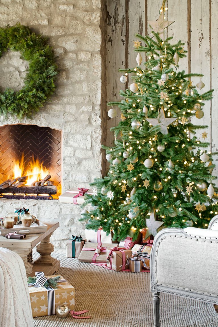 árboles de navidad originales decorados con adornos navideños en dorado, precioso salón en estilo rústico con chimenea de leña