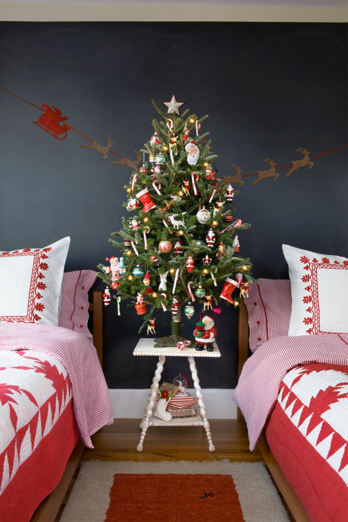 arboles navideños decorados de manera tradicional, dormitorio con dos camas, pequeño árbol navideño con adornos en rojo 