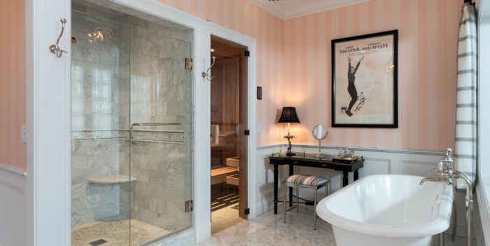 precioso cuarto de baño de diseño decorado en estilo vintage, papel pintado en rayas en rosado y beige, bañera vintage 