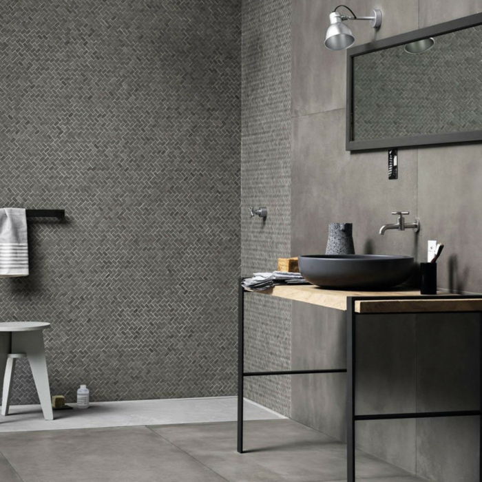 baños grises decorados en estilo industrial, paredes con azulejos de diseño, espejo moderno, asuelo con baldosas grises 