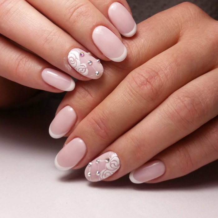 diseño delicado y elegante de uñas de acrilico pintadas en rosado claro, uñas francesas con elementos decorativos, motivos florales 