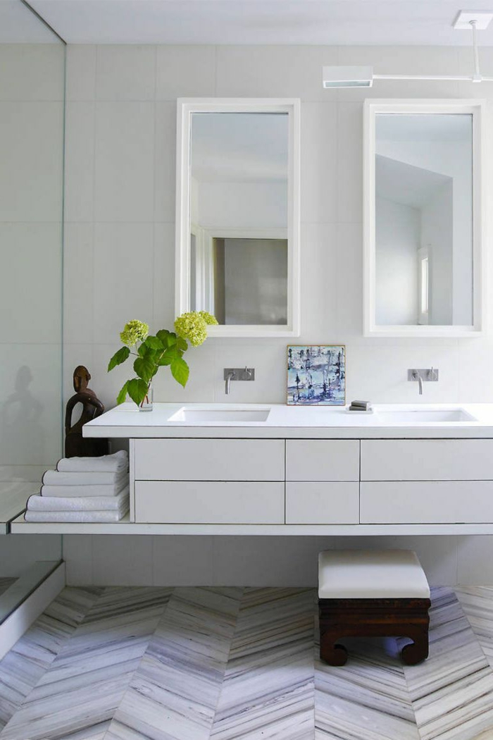pequeño baño decorado en blanco y gris claro, azulejos de diseño, dos espejos modernos, pequeño taburete vintage 