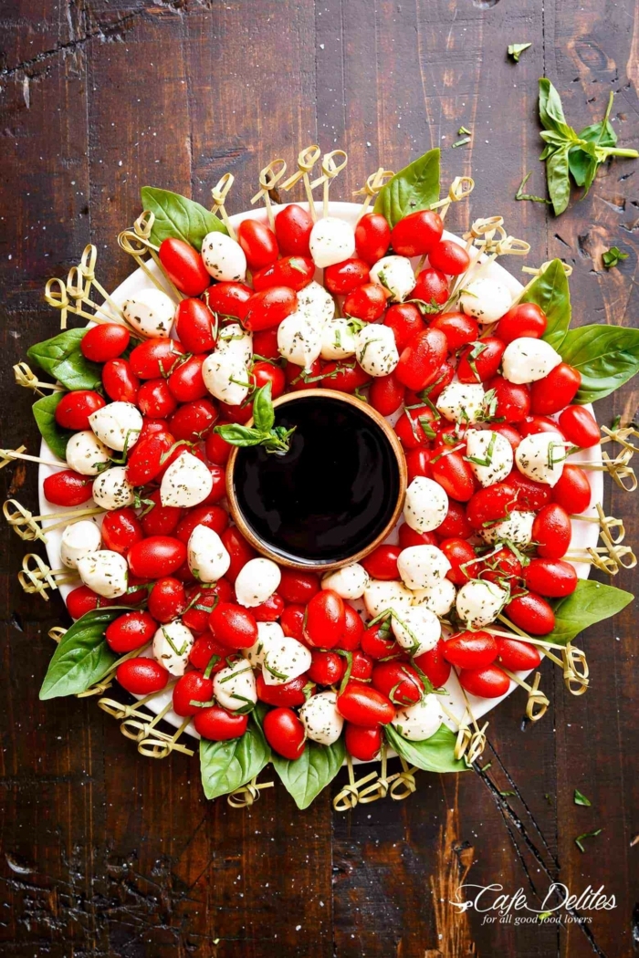 preciosas ideas de canapes navideños decorados, corona de navidad, ensalada caprese con queso mozzarella, tomates, albahaca