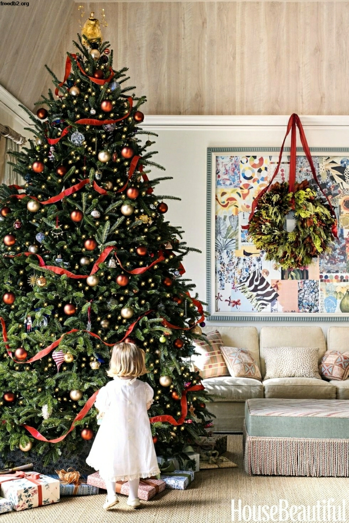 preciosa decoración navideña, grande árbol decorado con adornos en dorado y rojo y cintas de tela rojas