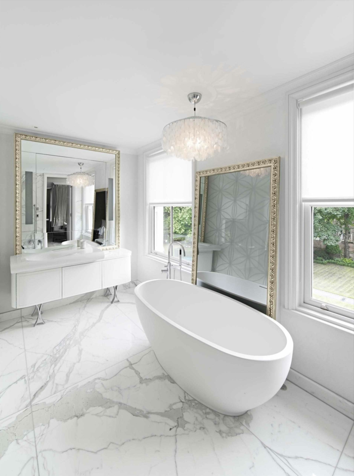 baños grises decorados en estilo contemporáneo con muebles en estilo vintage, grandes espejos con marcos en dorado 