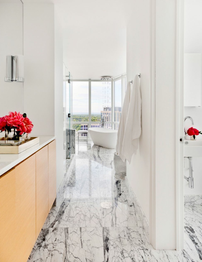 cuarto de baño de diseño con suelo de mármol, muebles modernos y decoración en blanco