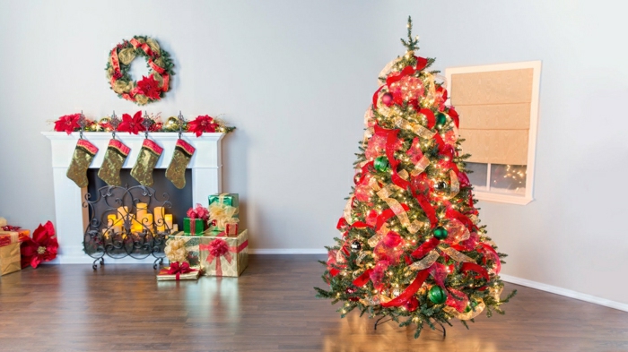decoración de árbol navideño con cintas de tela en rojo y dorado, chimenea de leña, salón grande acogedor 