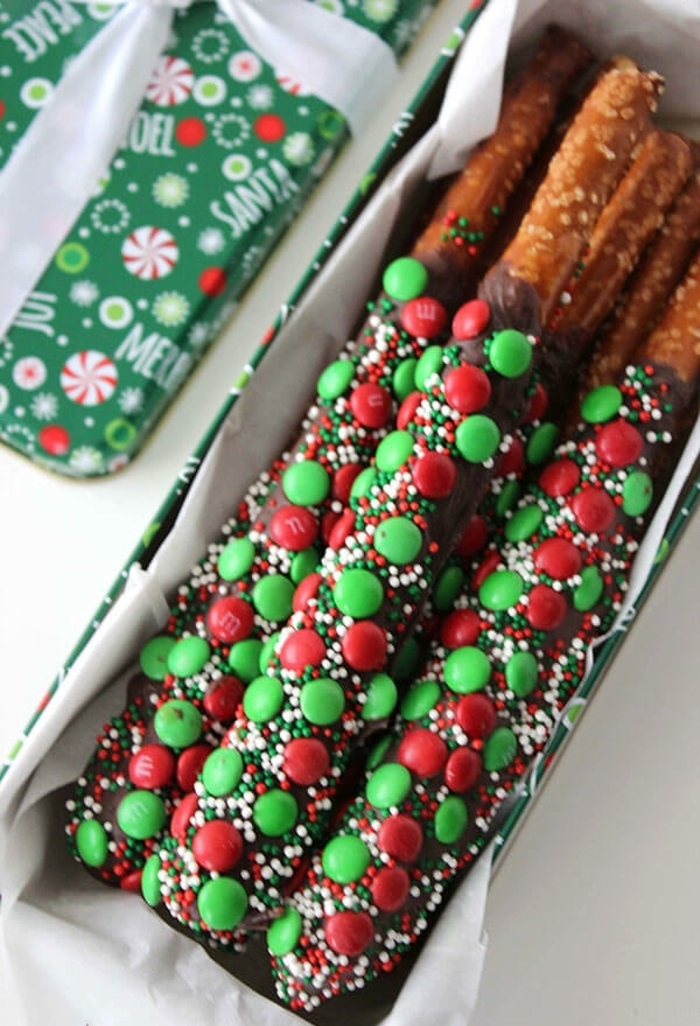 palitos de chocolate hechos con pretzels y chocolate adornados de caramelos en verde y rojo 