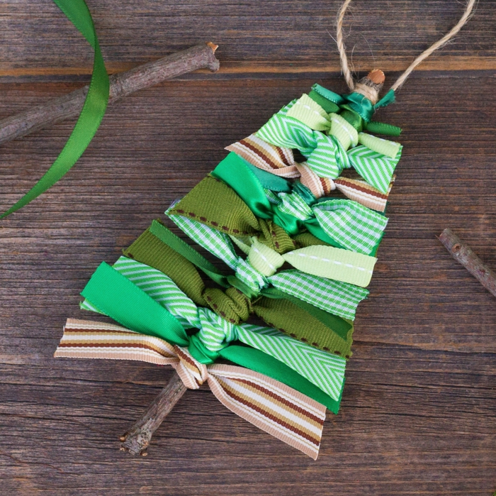 ideas de adornos navideños reciclados, árbol navideño hecho de palos de madera y cintas de tela en verde 