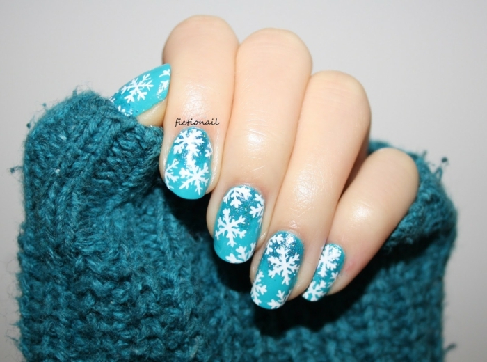 manicura bonita, uñas pintadas en azul claro con decoración en blanco, dibujos uñas de copos de nieve 
