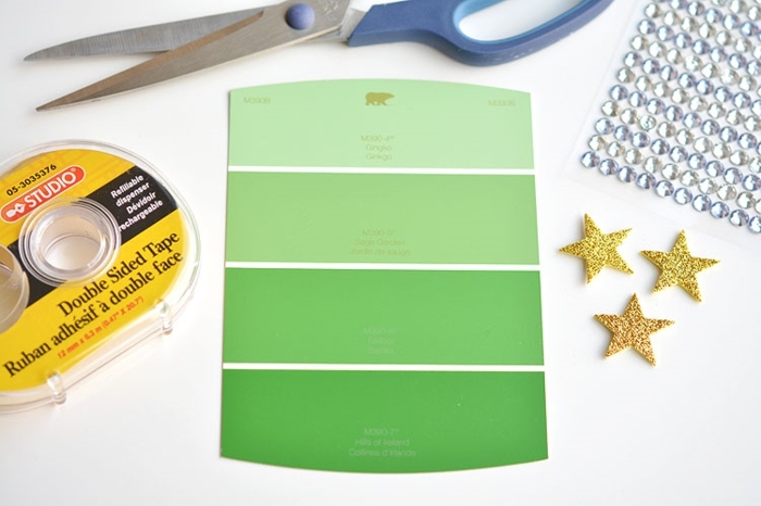 materiales necesarios para hacer postales navideñas personalizadas, cinta adhesiva, tijeras, estrellas doradas para pegar 