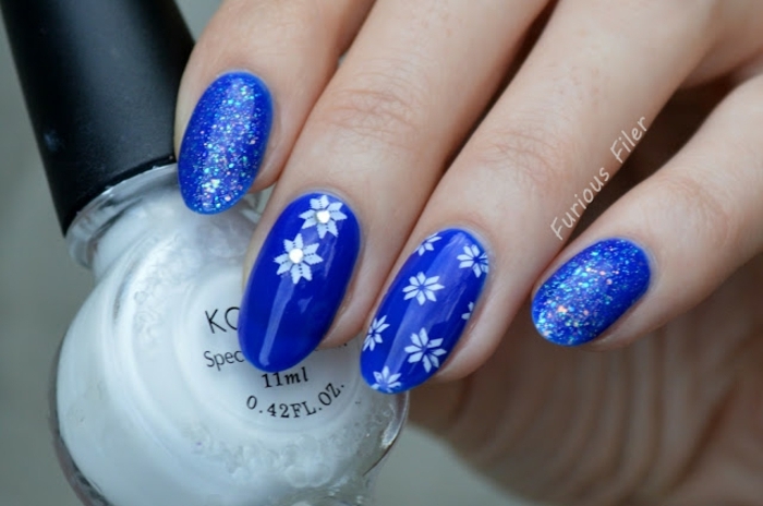 uñas de gel decoradas de forma almendrada pintadas en azul con decoraciones, dibujo de copos de nieve 